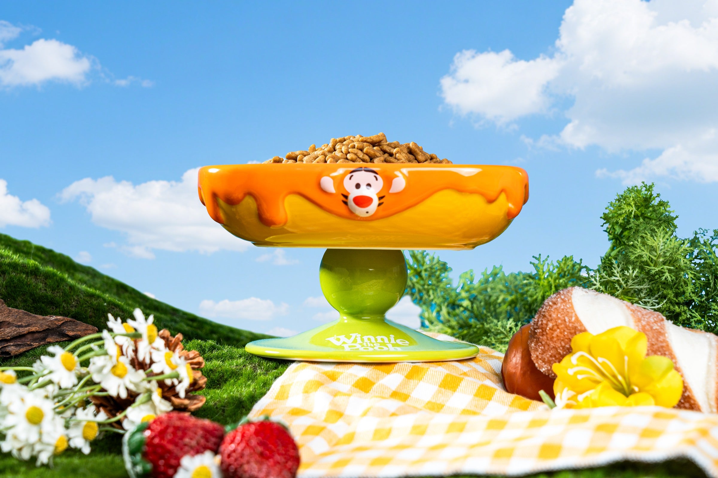 Raised feeding bowl with Tigger’s face, an orange rim and a green Winnie the Pooh pedestal